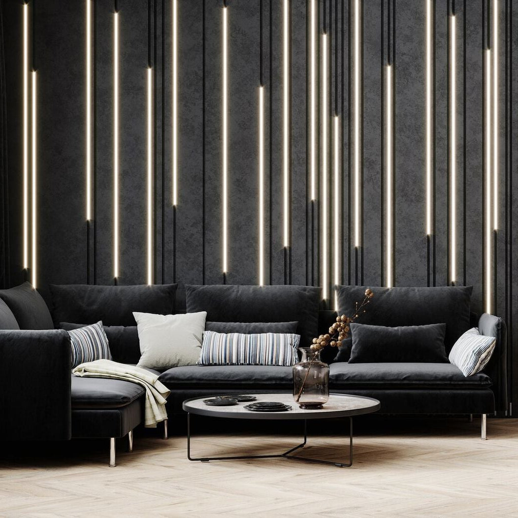 Modern living room with black sofa, coffee table, and chair against a decorative wall.