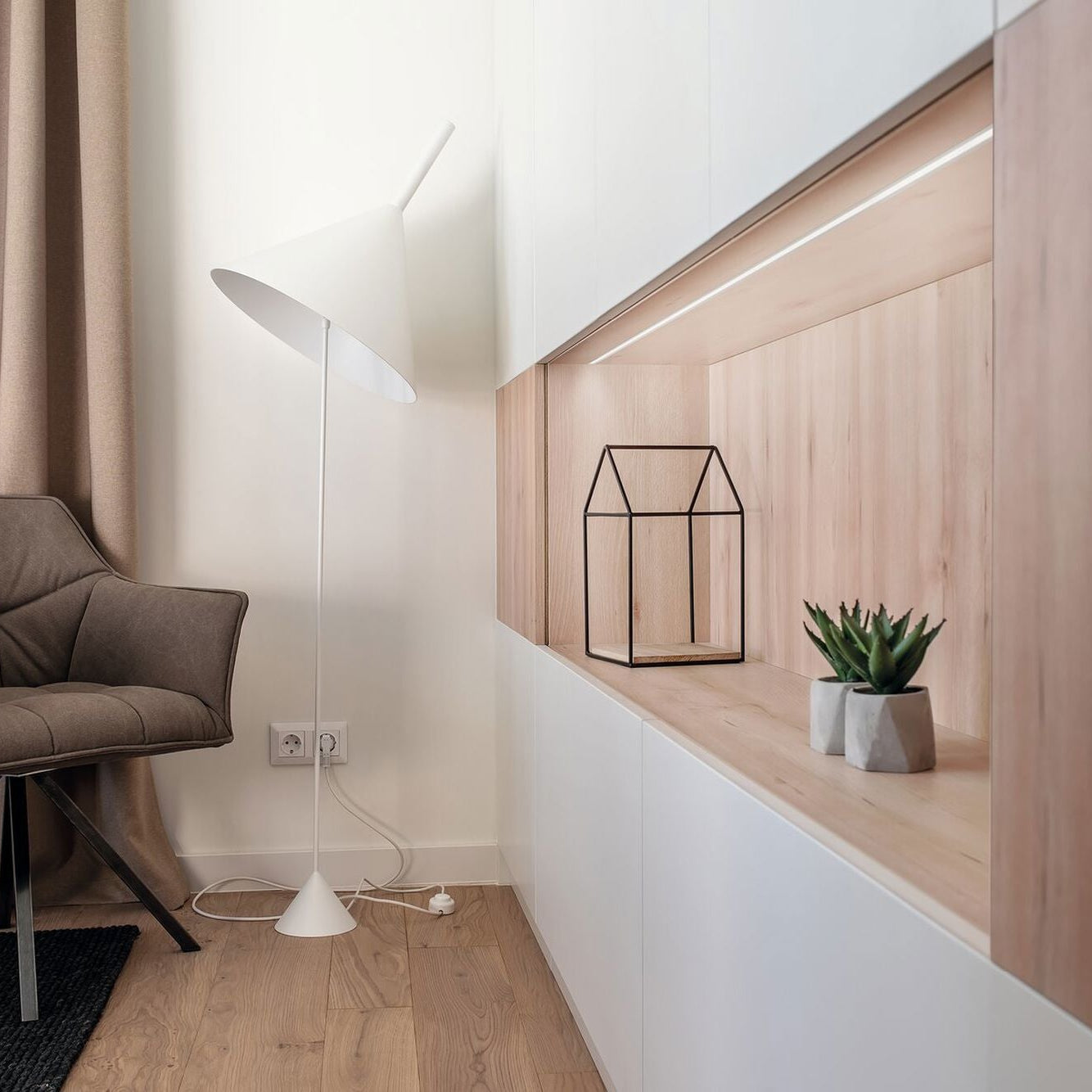 Modern interior with a chair, floor lamp, and decorative elements.