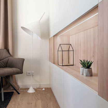 Modern interior with a chair, floor lamp, and decorative elements.